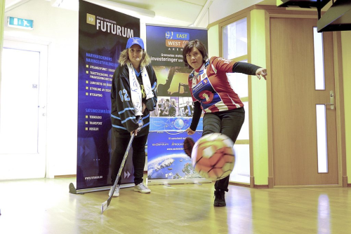 Ann-Hege Lund med ishockeykølle, Hanne Winther med fotball, begge ansatt i Futurum
